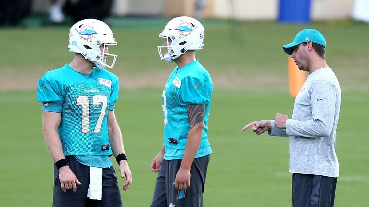 Miami Dolphins quarterback Ryan Tannehill and coach Adam Gase interact at a practice last week. The Dolphins are keeping four quarterbacks for now.