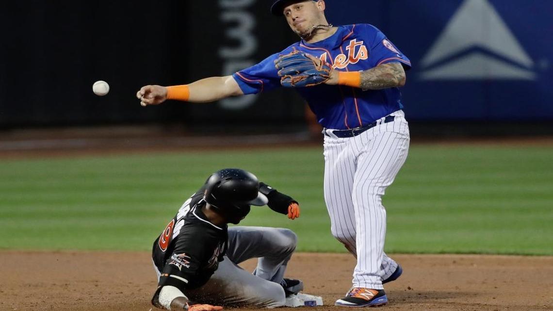 New York Mets' Asdrubal Cabrera (13) throws out Miami Marlins' Giancarlo Stanton at first base after forcing out Dee Gordon (9) during the third inning of a baseball game Saturday, Aug. 19, 2017, in New York.