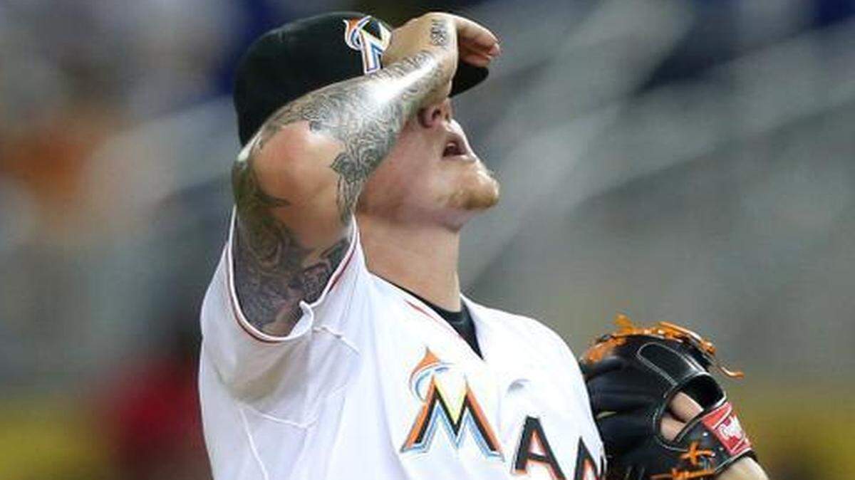 Miami Marlins pitcher Mat Latos reacts after Atlanta Braves first baseman Freddie Freeman hits a two-run double in the first inning at Marlins Park in Miami, Tuesday, April 7, 2015.