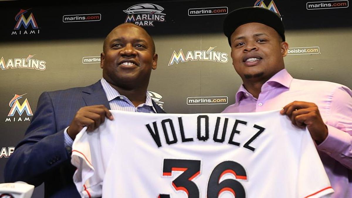 Miami Marlins' president of baseball operations Michael Hill introduces pitcher Edinson Volquez during a press conference to announce his signing of a two-year contract through the 2018 season at Marlins Park in Miami on Dec. 1, 2016.