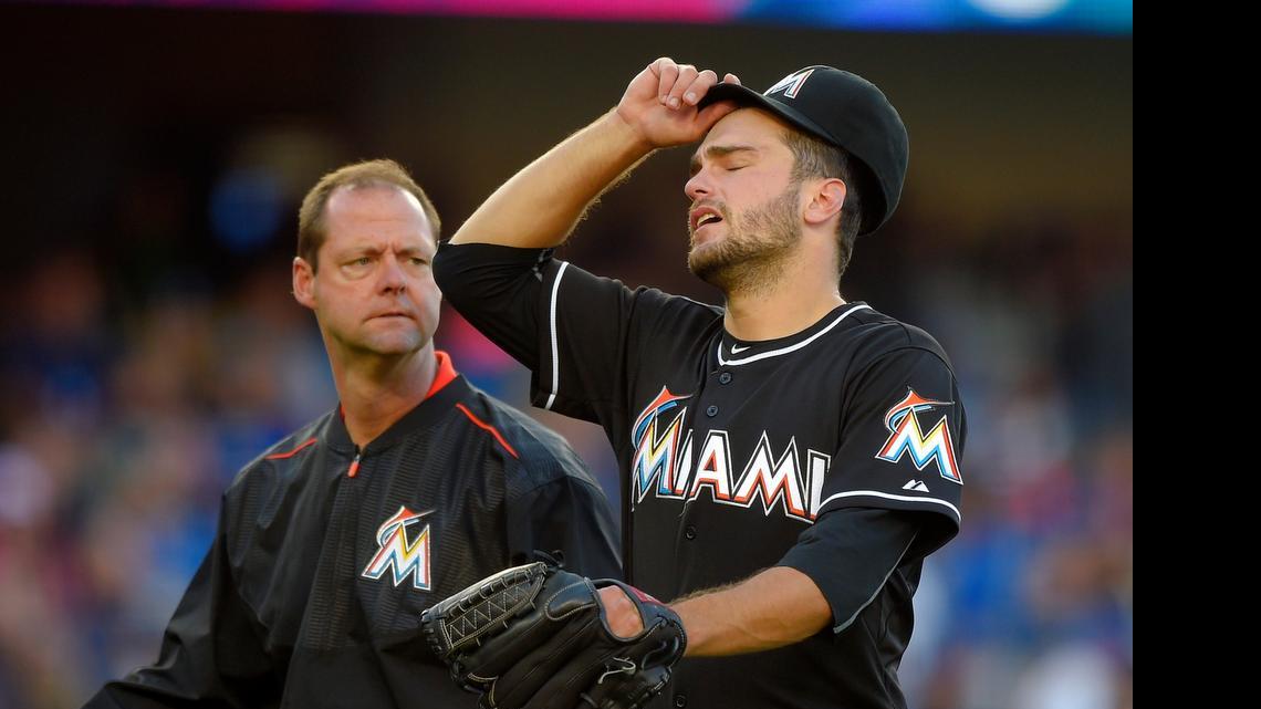 
Miami Marlins pitcher Jarred Cosart, right, walks off the field with a trainer after being taken out of the game during the sixth inning Wednesday, May 13, 2015, in Los Angeles.
