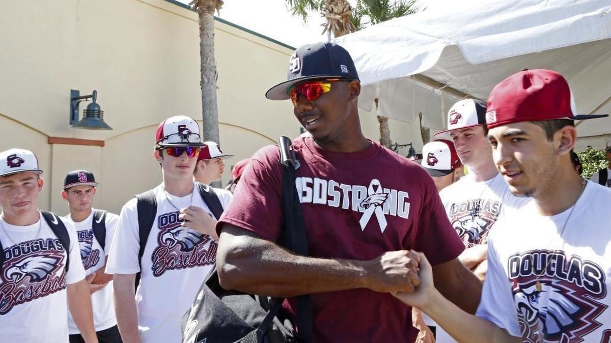 Miami Marlins outfielder Lewis Brinson shakes hands with Marjory Stoneman Douglas baseball player Jhan Ledezma before the start of a spring training baseball game against the St. Louis Cardinals at Roger Dean Chevrolet Stadium on Friday, Feb. 23, 2018, in Jupiter. The Marlins are honoring Stoneman Douglas shooting victims with special hats, T-shirts, patches.