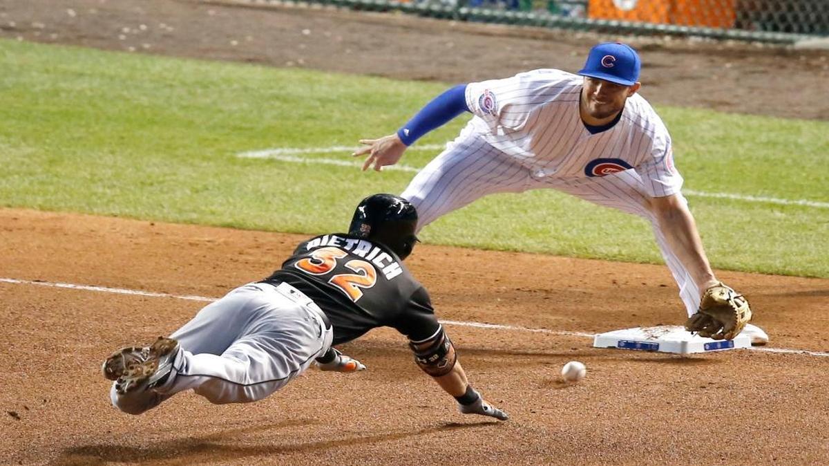 Chicago Cubs third baseman Kris Bryant, right catches Miami Marlins' Derek Dietrich trying to stretch his double to a triple off of throws from right fielder Jason Heyward to Javier Baez to Bryant during the fourth inning of a baseball game, Mon., Aug. 1, 2016, in Chicago.