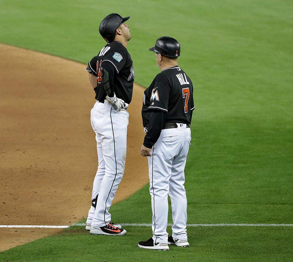 Marlins first base coach Perry Hill runs to check third baseman Martin Prado who got hurt after reaching to first base on error by Washington's short stop Trea Turner in the sixth inning of the Miami Marlins vs Washington Nationals game at Marlins Park, Friday, May 25, 2018.