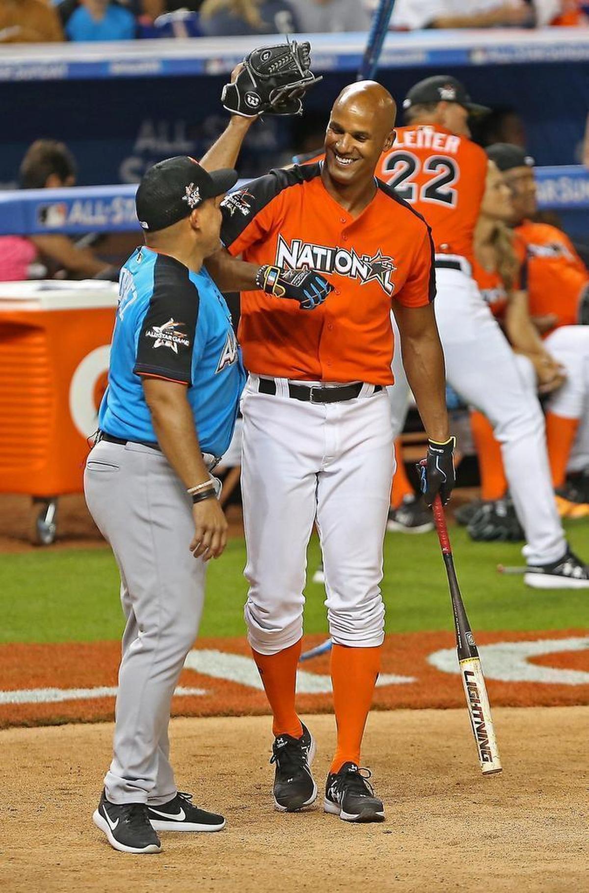 Pudge Rodriguez messes with Jason Taylor as he comes up to bat during the celebrity softball game at Marlins Park on Sunday.