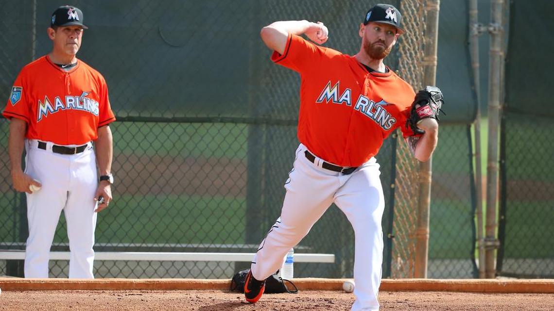 Miami Marlins pitching coach Juan Nieves looks as pitcher Dan Straily pitches during the spring training baseball workouts Wednesday.