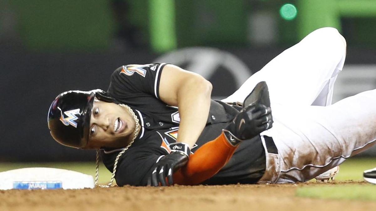 Miami Marlins' Giancarlo Stanton rolls over at second base after he was put out during the ninth inning of a baseball game, Saturday, Aug. 13, 2016, in Miami. Stanton singled with two out in the ninth but was an easy out trying to stretch the hit into a double.