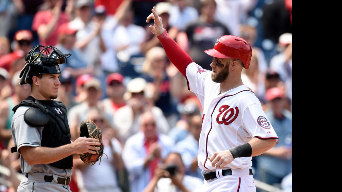 
The Nationals’ Bryce Harper responds to the crowd in the third inning after hitting the second of his three home runs Wednesday, May 6, 2015 in Washington. At left is Marlins catcher J.T. Realmuto. 
