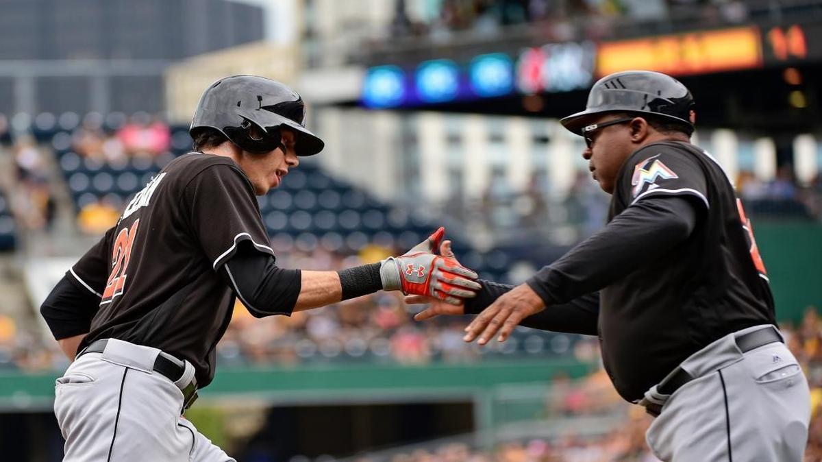 Miami Marlins' Christian Yelich, left, is congratulated by Lenny Harris after hitting a home run in the first inning of a baseball game against the Pittsburgh Pirates in Pittsburgh, Sunday, Aug. 21, 2016.