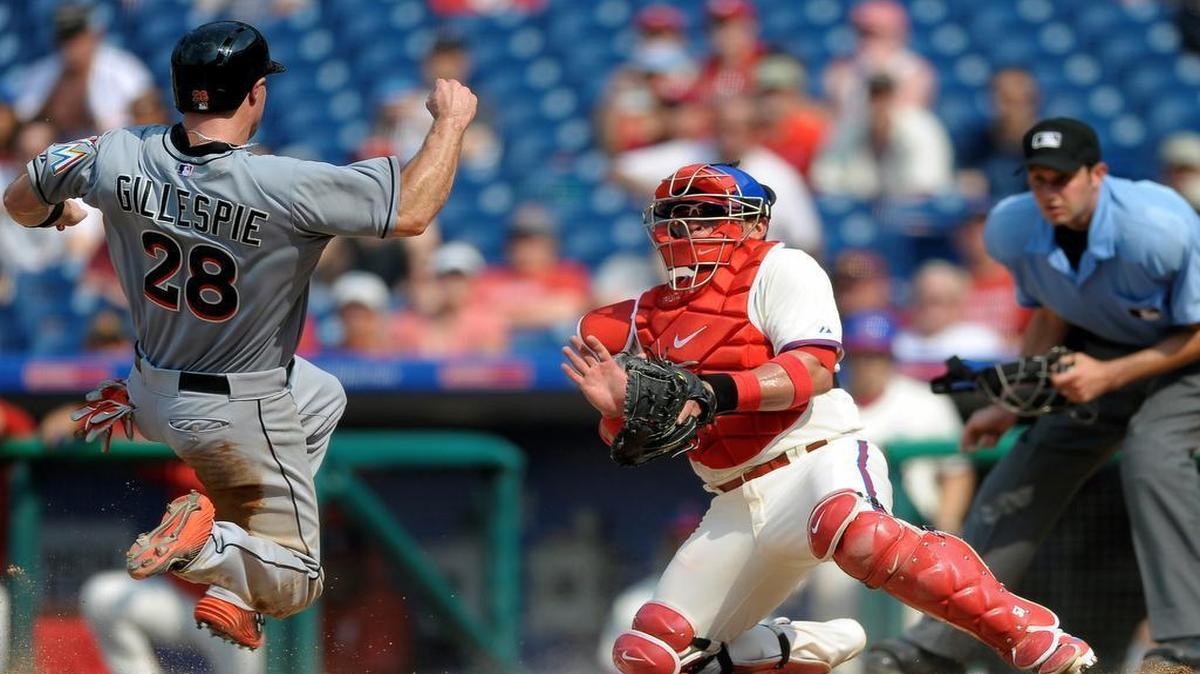 
Miami Marlins' Cole Gillespie (28) scores a run past Philadelphia Phillies catcher Carlos Ruiz, center, off a Jeff Mathis sacrifice fly in the eighth inning of a baseball game, Sunday, July 19, 2015, in Philadelphia. The Phillies won 8-7. 
