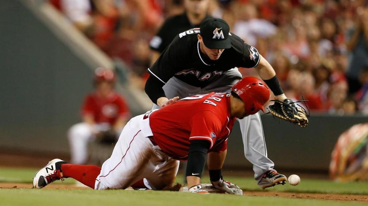 Cincinnati Reds' Ramon Cabrera, front, is safe at first as Miami Marlins first baseman Chris Johnson, loses the throw during the sixth inning of a baseball game Thurs., Aug. 18, 2016, in Cincinnati.