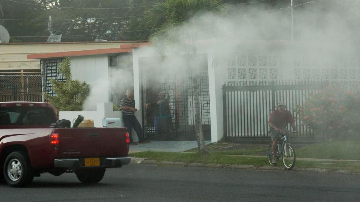 Residents are blanketed in a cloud of permethrin as a team from the Puerto Rico department of health sprays the insecticide the neighborhood of Cupey, in San Juan, Puerto Rico.