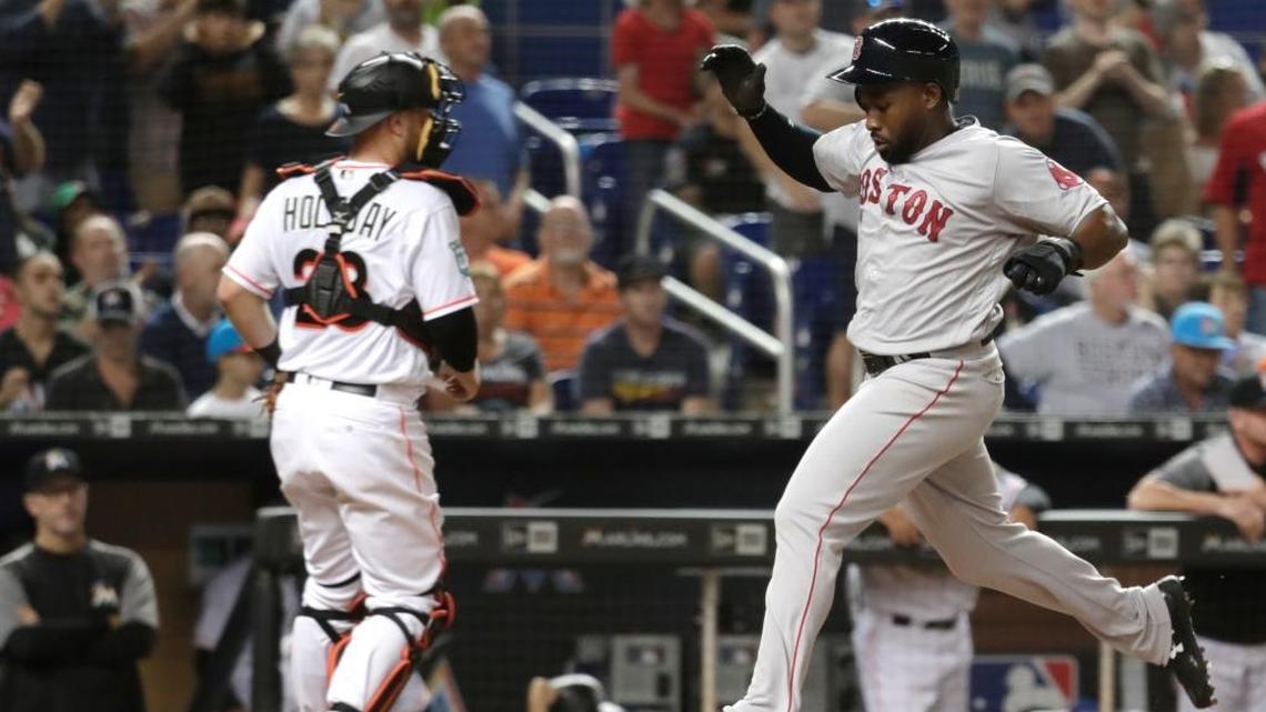 Boston Red Sox's Jackie Bradley Jr., right, scores past Miami Marlins catcher Bryan Holaday on double hit by Christian Vazquez in the fourth inning during a baseball game, Monday, April 2, 2018, in Miami.