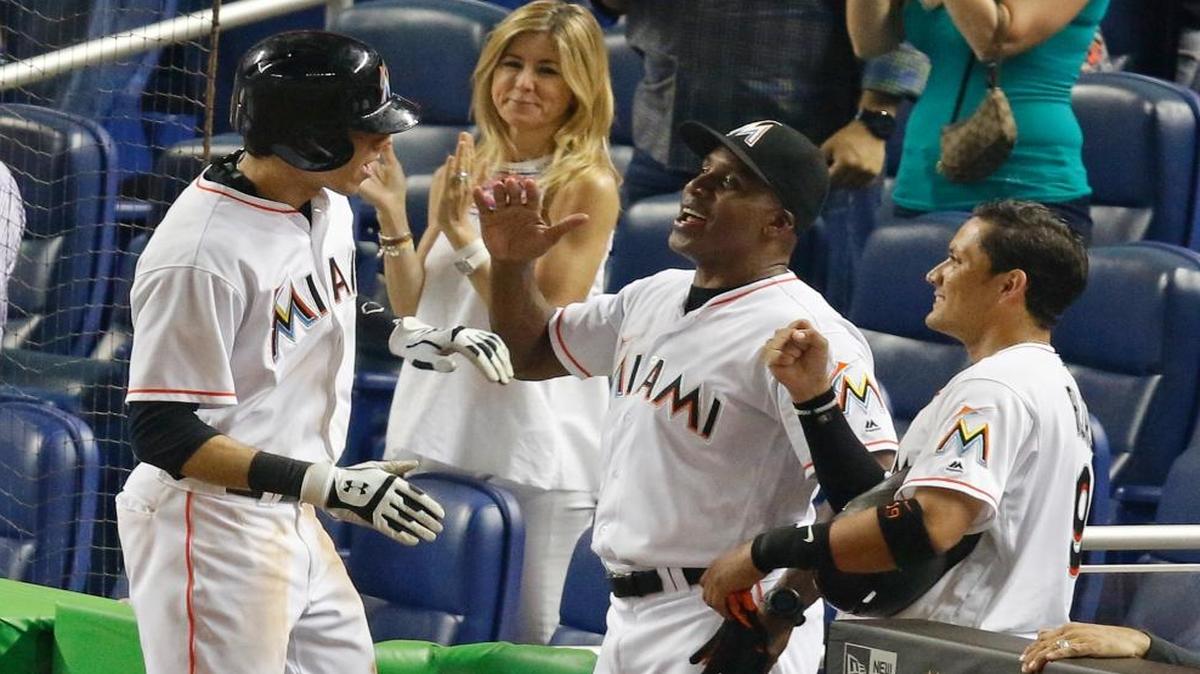 Miami Marlins' Christian Yelich, left, is congratulated by hitting coach Barry Bonds, center, after his sixth-inning, two-run home run against the New York Mets during a baseball game in Miami, Fri., July 22, 2016.