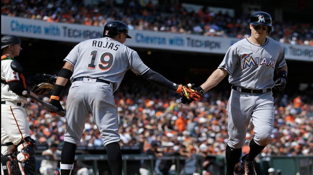 Miami Marlins' J.T. Realmuto, right, is congratulated by Miguel Rojas (19) after hitting a home run off San Francisco Giants' Josh Osich in the eighth inning of a baseball game Sunday, April 24, 2016, in San Francisco.