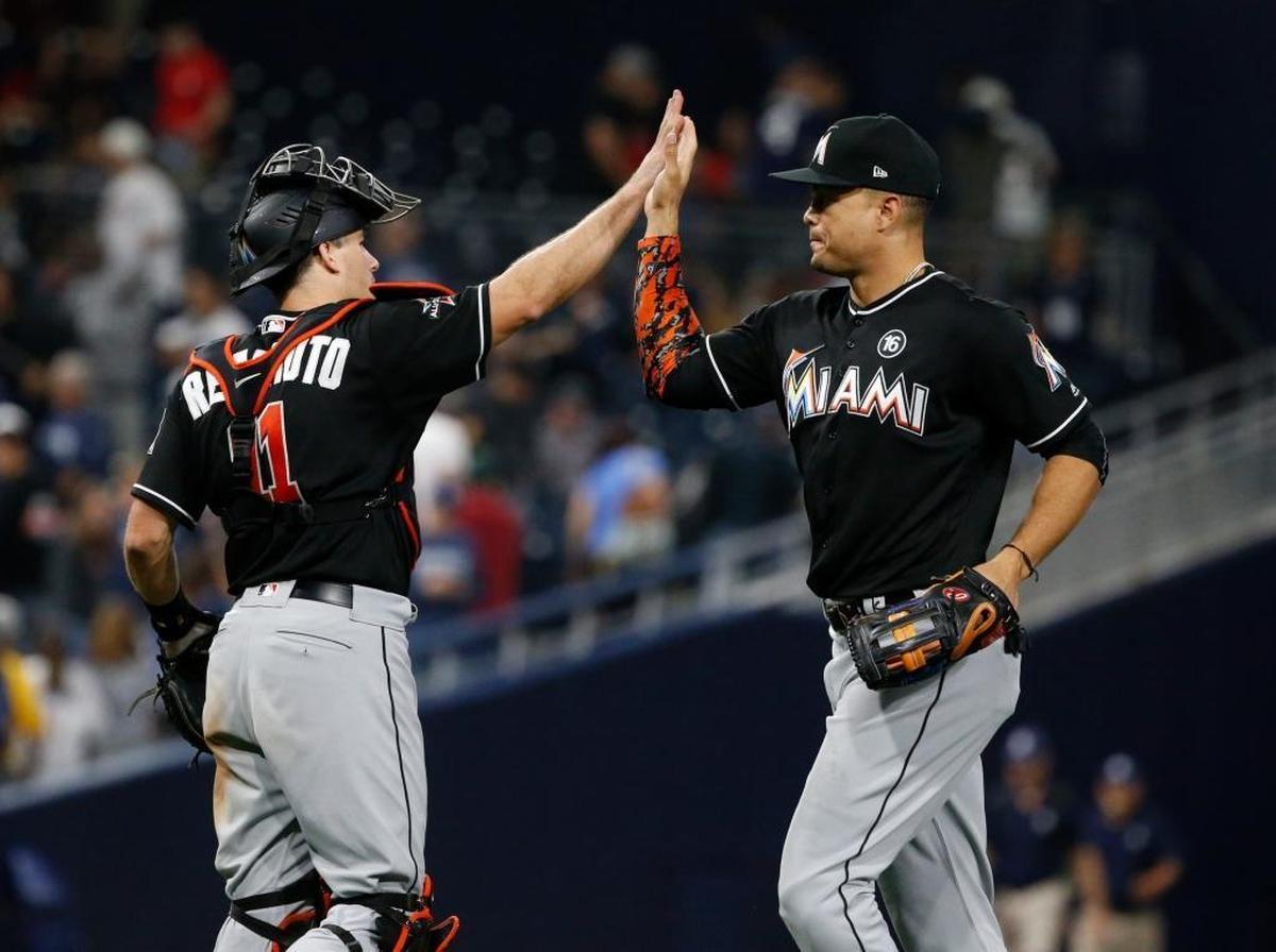 Miami Marlins' Giancarlo Stanton, right, and catcher J.T. Realmuto celebrate after a baseball game against the San Diego Padres in San Diego, Saturday, April 22, 2017. The Marlins won 6-3.