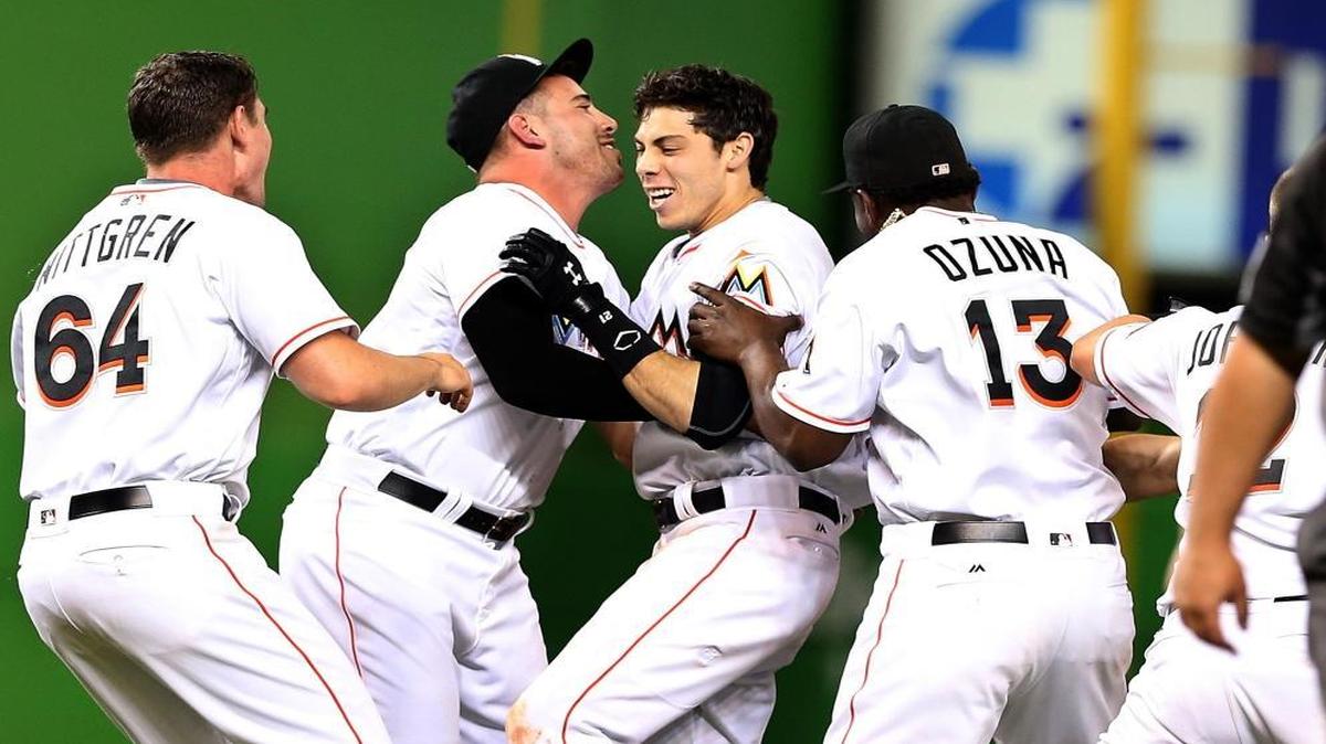 Marlins' players greet left fielder Christian Yelich after his game-winning RBI double in the 12th inning for a 4-3 victory against the Pittsburgh Pirates at Marlins Park in Little Havana in Miami on Thurs., June 2, 2016.