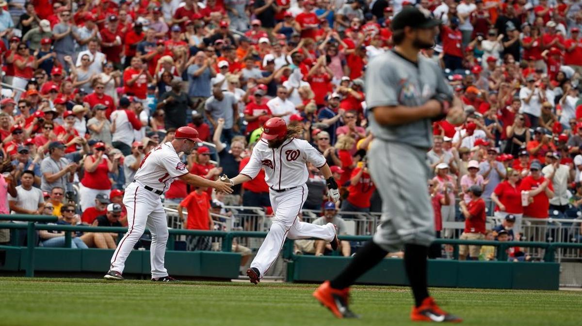 
Washington Nationals third base coach Bob Henley, left, shakes hands with Jayson Werth who rounds the bases for a two-run home run off Miami Marlins starting pitcher Brad Hand, right, during the third inning of a baseball game at Nationals Park, Sunday, Aug. 30, 2015, in Washington.
