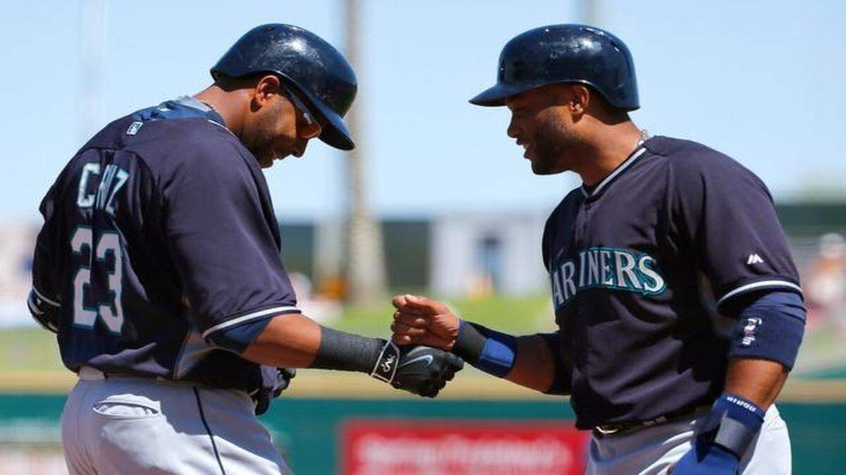 
Seattle Mariners' Nelson Cruz (23) smiles as he celebrates his two-run home run against the Cleveland Indians with Robinson Cano, right, during the first inning of a spring training baseball game Tuesday, March 31, 2015, in Goodyear, Ariz. 
