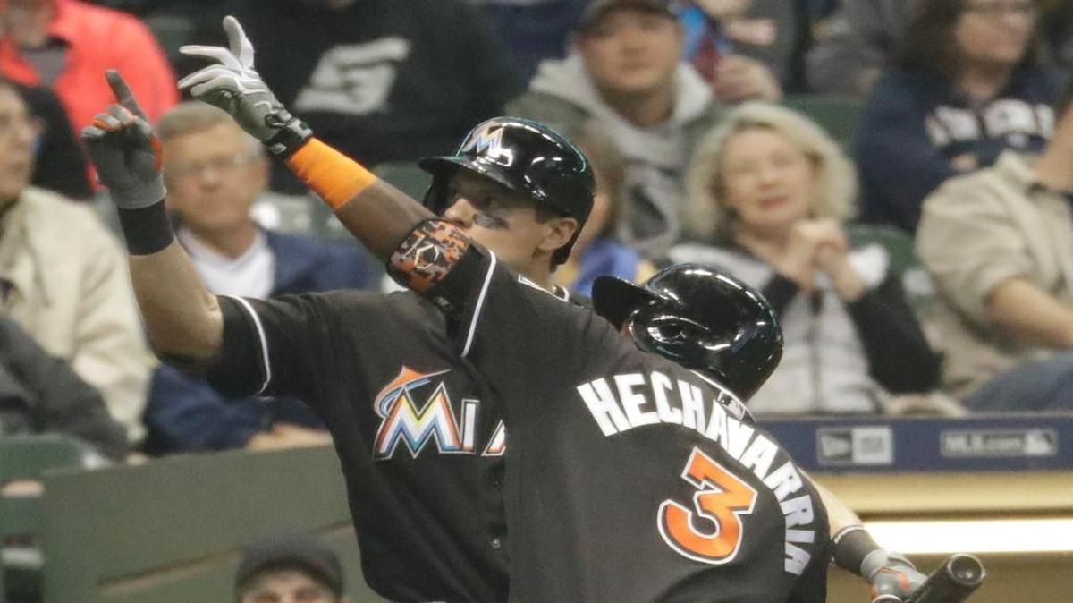 Miami Marlins' Adeiny Hechavarria has some fun with teammate Derek Dietrich after Hechavarria's home run during the second inning of a baseball game against the Milwaukee Brewers Saturday, April 30, 2016, in Milwaukee.