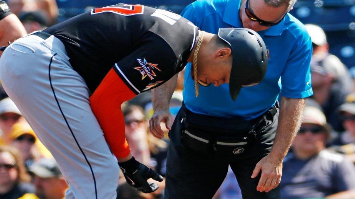 A team trainer, right, examines the hand of Miami Marlins' Giancarlo Stanton, left, after Stanton was hit by a pitch from Pittsburgh Pirates starter Trevor Williams in the first inning of a baseball game in Pittsburgh, Saturday, June 10, 2017. Stanton left the game after the examination.