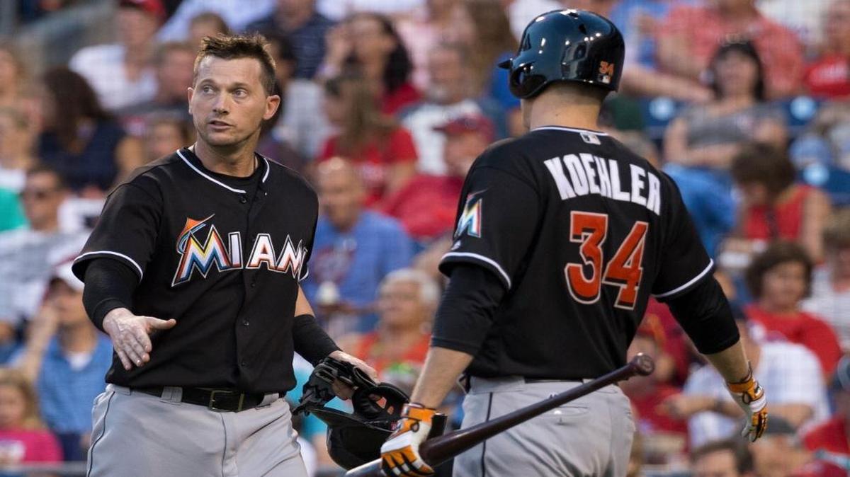 Miami Marlins' Chris Johnson, left, looks up as he is about to celebrate his run with Tom Koehler, right, during the fourth inning of a baseball game against the Philadelphia Phillies, Thurs., July 21, 2016, in Philadelphia.