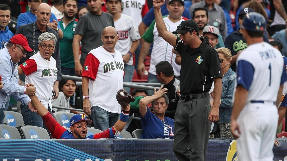 Venezuela third baseman Martin Prado is helped by a baseball fan after Prado dove into the stands to make a catch in the eighth inning of a World Baseball Classic game against Italy, in Guadalajara, Mexico, on March 11.