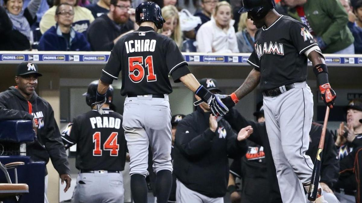 Miami Marlins' Ichiro Suzuki is congratulated by Marcell Ozuna as reaches the dugout after scoring on home run hit by Martin Prado during the third inning of a baseball game Monday, June 13, 2016, in San Diego.