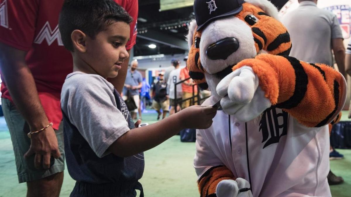 Gabriel Palacio, 3, receives an autographed card from the Detroit Tigers mascot at the MLB All-Star FanFest on Saturday.