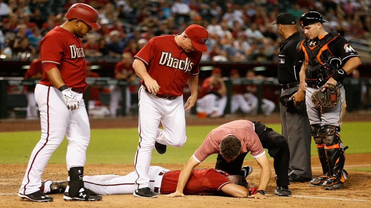 
David Peralta #6 of the Arizona Diamondbacks is looked at by Yasmany Tomas #24, manager Chip Hale #3 and a team trainer after being hit in the head by a pitch from starting pitcher Jose Fernandez (not pictured) of the Miami Marlins during the sixth inning of the MLB game at Chase Field on July 22, 2015 in Phoenix, Arizona.
