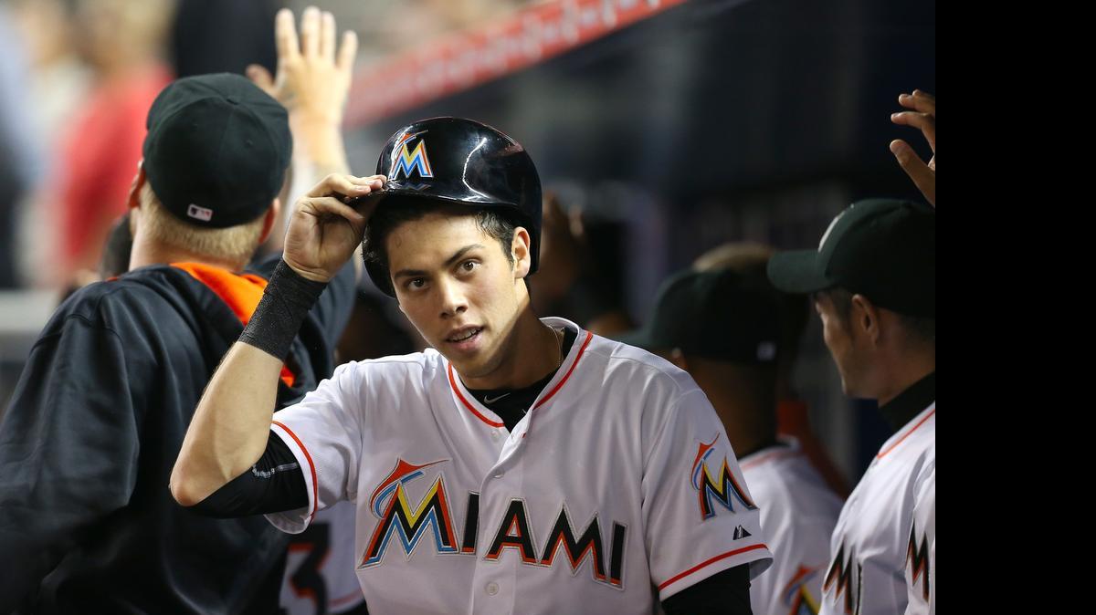 
Miami Marlins left fielder Christian Yelich is congratulate by teammates after scoring on Giancarlo Stanton two-run double in the fourth inning against the Tampa Bay Rays during their interleague baseball game at Marlins Park in Miami on April 10, 2015.
