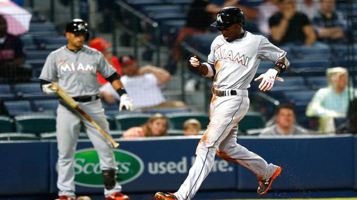 
Miami Marlins infielder Dee Gordon (9) scores on a single by Giancarlo Stanton during the fourth inning of their game against the Atlanta Braves at Turner Field in Atlanta on April 14, 2015.
