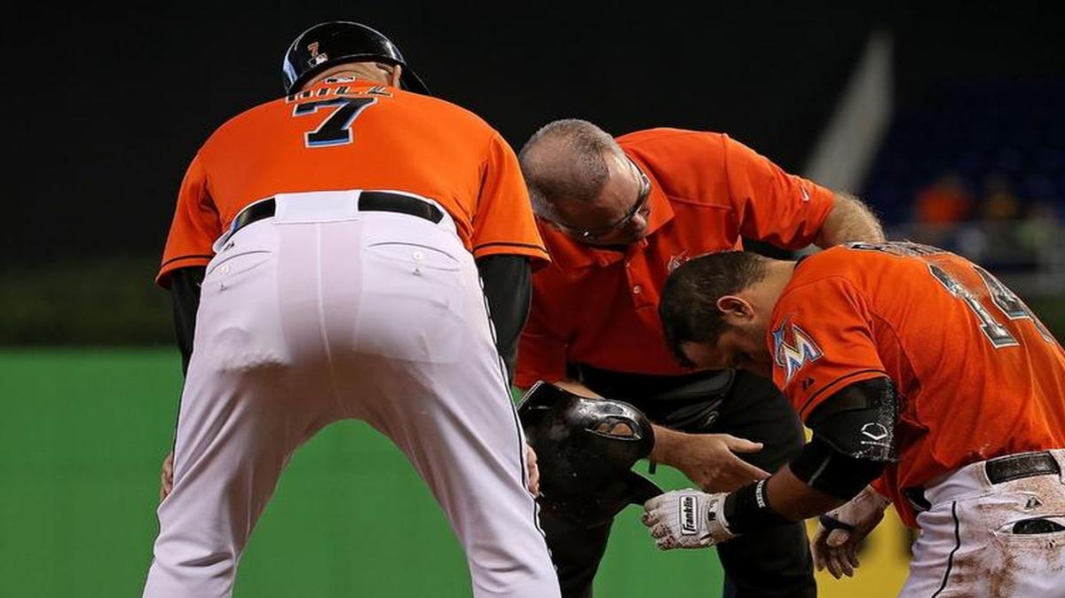 
Martin Prado #14 of the Miami Marlins reacts to injuring his shoulder after falling crossing first base during a game against the Colorado Rockies at Marlins Park on June 14, 2015 in Miami, Florida. 
