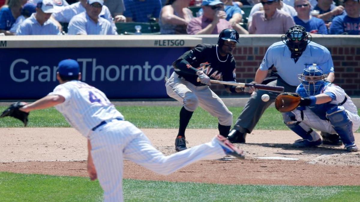 Miami Marlins' Dee Gordon lays down a bunt single off a pitch from Chicago Cubs starting pitcher John Lackey during the third inning of a baseball game Wed., Aug. 3, 2016, in Chicago.