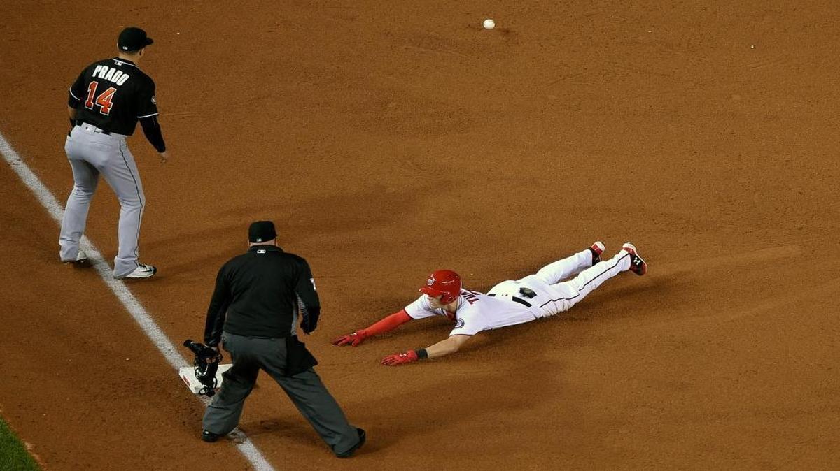 Washington Nationals' Trea Turner, right, slides toward third for a triple during the third inning of a baseball game as Miami Marlins third baseman Martin Prado (14) awaits the ball, Fri., Sept. 30, 2016, in Washington.