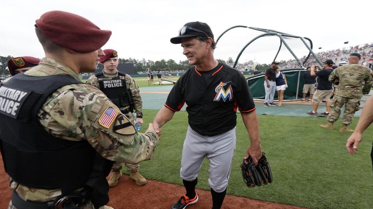 Miami Marlins manager Don Mattingly, center, greets military police prior to a baseball game against the Atlanta Braves in Fort Bragg, N.C., Sunday, July 3, 2016. The game will be the first regular-season game of a professional sport played on an active military installation.