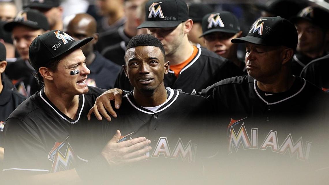Miami Marlins' Dee Gordon (9), center, gets consoled by Derek Dietrich (32), left, after hitting a home run during the first inning of a baseball game against the New York Mets at Marlins Park in Little Havana on Mon., Sept. 26, 2016.