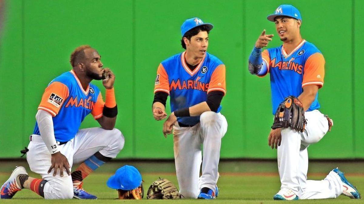 Marlins left fielder Marcell Ozuna (13), center fielder Christian Yelich (21) and right fielder Giancarlo Stanton (27), left to right, take a break during a pitching change as the Marlins host the San Diego Padres at Marlins Park on Friday, Aug. 25, 2017.
