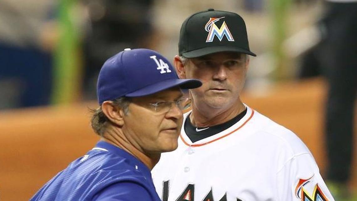 Don Mattingly, manager of the Los Angeles Dodgers, and Dan Jennings, manager of the Miami Marlins, exchange lineup cards before a game Friday, June 26, 2015 at Marlins Park in Miami.