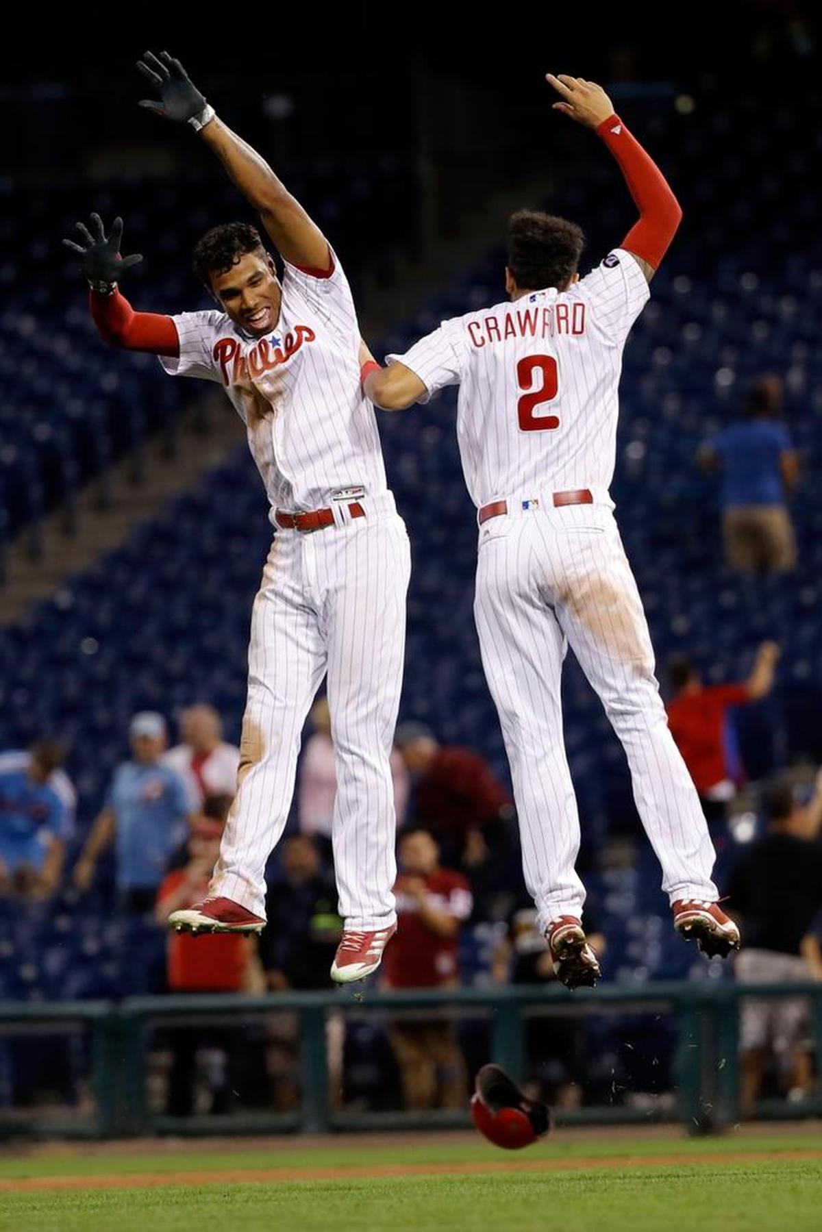 Philadelphia Phillies' Nick Williams, left, and J.P. Crawford celebrate after Williams' double drove in the the winning run during the 15th inning against the Miami Marlins, early Wednesday, Sept. 13, 2017, in Philadelphia. Philadelphia won 9-8.