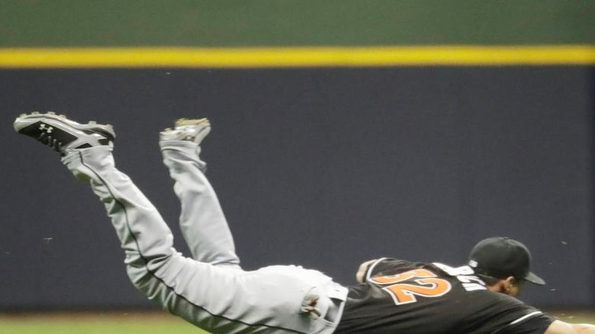 Miami Marlins' Derek Dietrich can't catch a ball hit by Milwaukee Brewers' Jonathan Lucroy during the ninth inning of a baseball game on April 29, 2016 in Milwaukee. The hit was the first of the game for the Brewers.