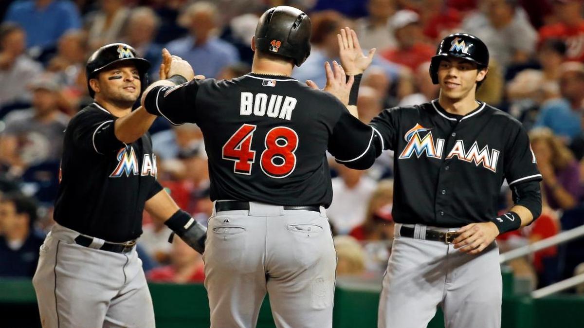 
Miami Marlins' Martin Prado, left, and Christian Yelich, right, congratulate Justin Bour (48) after they scored on Bour's three-run home run during the fifth inning of a baseball game against the Washington Nationals at Nationals Park, Thursday, Sept. 17, 2015, in Washington. 
