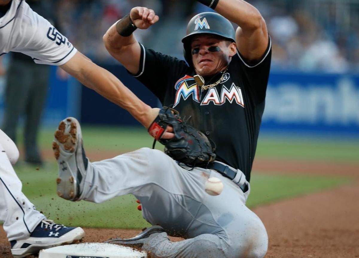 Miami Marlins' Derek Dietrich, right, avoids a pickoff-attempt by San Diego Padres first baseman Wil Myers in the fifth inning of a baseball game in San Diego, Saturday, April 22, 2017.