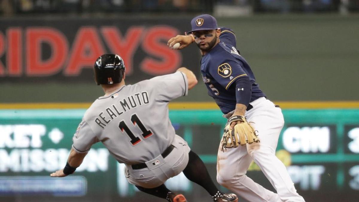 Miami Marlins' J.T. Realmuto is out at second as Milwaukee Brewers' Jonathan Villar turns a double play on a ball hit by Adeiny Hechavarria during the fourth inning of a baseball game Sunday, May 1, 2016, in Milwaukee.