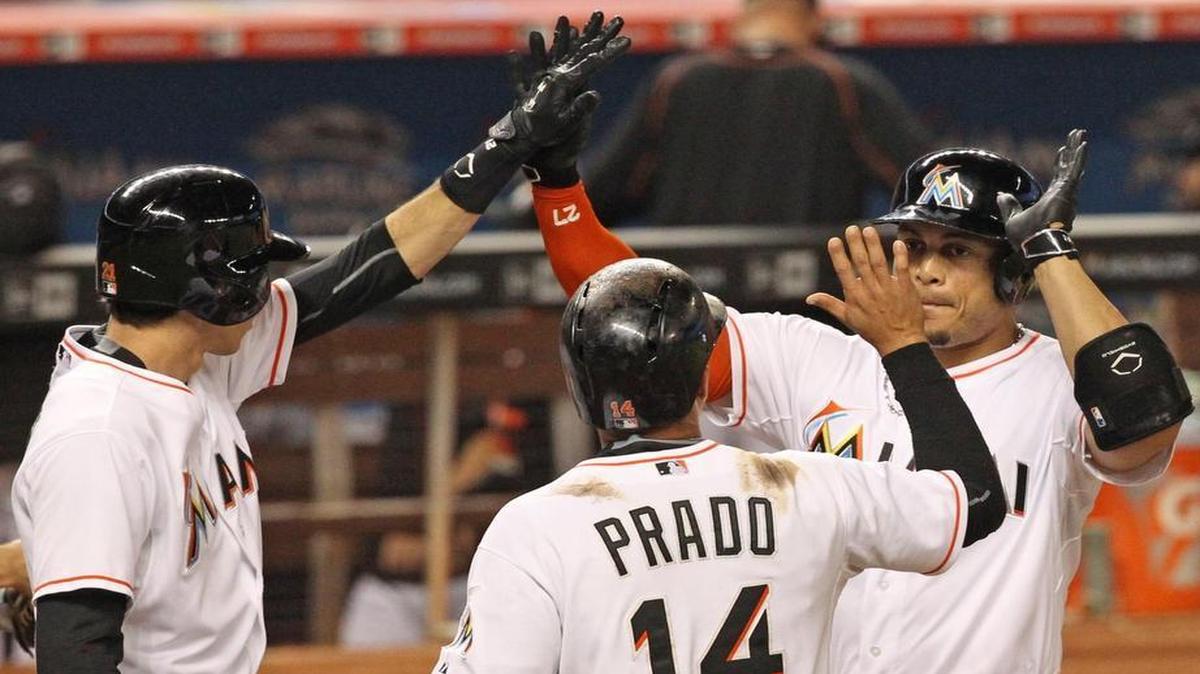 
Miami Marlins right fielder Giancarlo Stanton high fives with teammates Christian Yelich and and Martin Prado after hitting a three-run home run in the first inning of their game against the Colorado Rockies at Marlins Park in Miami on June 11, 2015.
