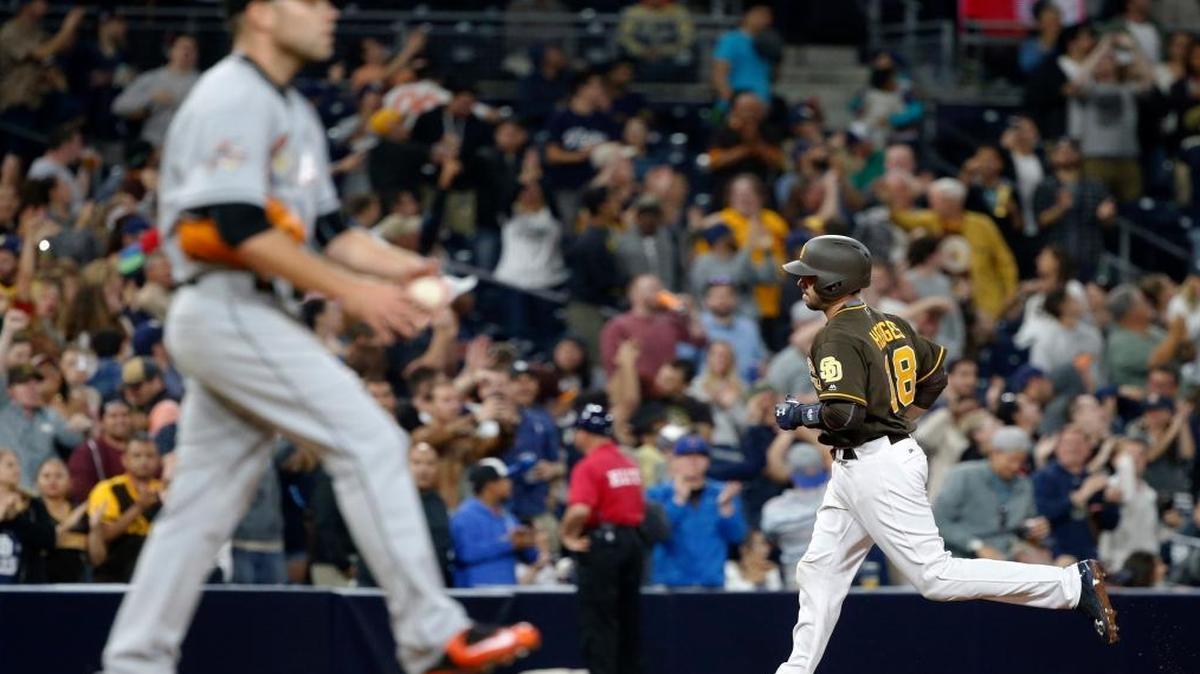 Miami Marlins pitcher David Phelps waits as San Diego Padres' Austin Hedges, right, rounds third base after hitting a three-run home run during the seventh inning of a baseball game in San Diego, Fri., April 21, 2017.