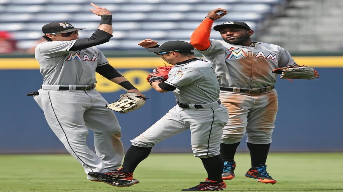 
Miami Marlins outfielders Christian Yelich, left, Ichiro Suzuki, center, and Marcell Ozuna celebrate after the final out in the ninth inning of a baseball game against the Atlanta Braves Wednesday, Sept. 2, 2015, in Atlanta. Miami won 7-3. 
