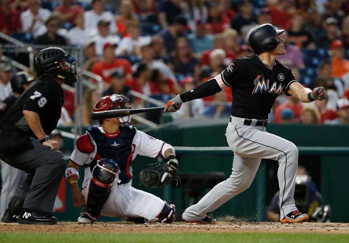 Miami Marlins' Derek Dietrich (32), with umpire Manny Gonzalez (79) and Washington Nationals catcher Jose Lobaton (59), watches his solo home run during the fourth inning of baseball game, Tues., Aug. 8, 2017, in Washington.