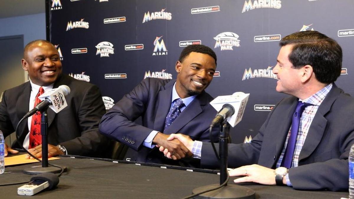 Miami Marlins second baseman Dee Gordon shakes hands with team president David Samson as president of baseball operations Michael Hill looks on Monday, January 18, 2016. Gordon officially signed a five-year, $50 million extension.