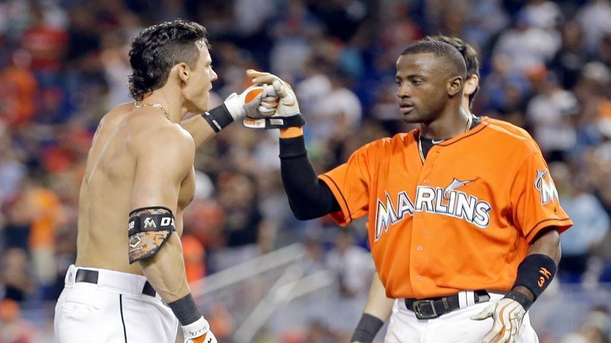 Miami Marlins' Derek Dietrich, left, is congratulated by teammate Adeiny Hechavarria after hitting a winning triple against the St. Louis Cardinals in the ninth inning of a baseball game, Sunday, July 31, 2016, in Miami. Hechavarria scored on the triple.